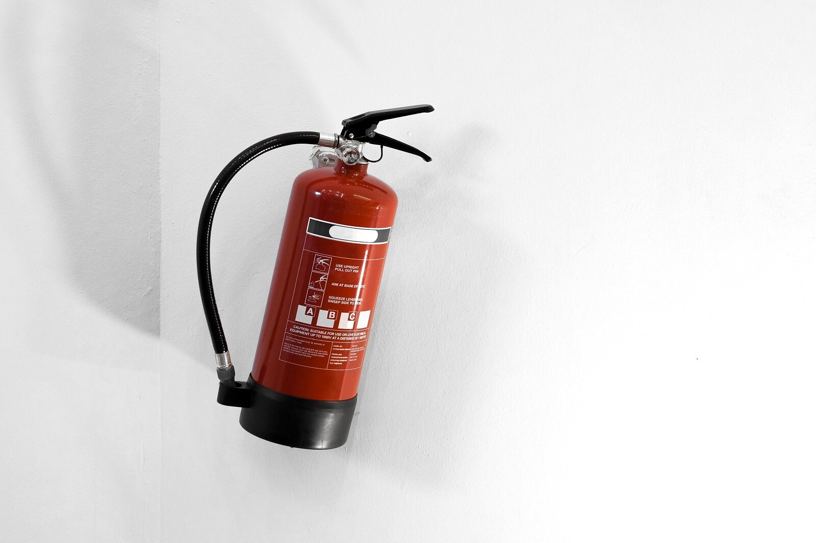 red-fire-extinguisher-white-wall